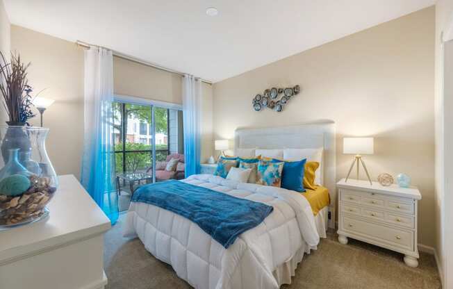 a bedroom with a bed and a sliding glass door to a balcony