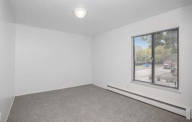 an empty bedroom with a large window