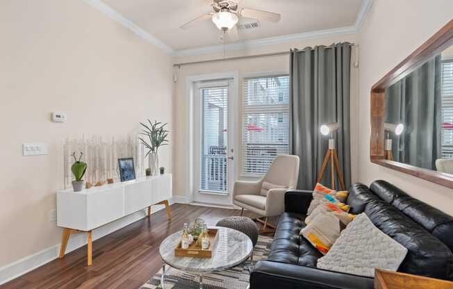 a living room with leather furniture and a ceiling fan