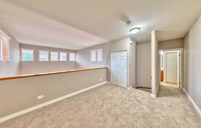 A room with a carpeted floor and a door on the right side.