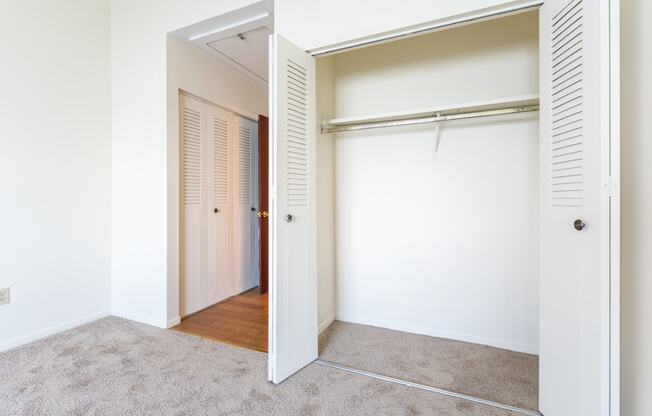 a bedroom with a closet and a door that is open