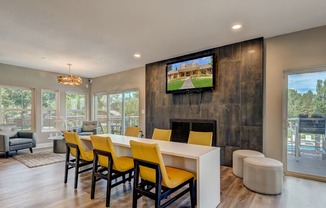 A modern living room with a television and yellow chairs.