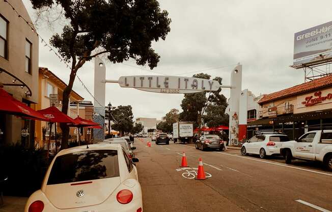 a city street with cars and a sign for little