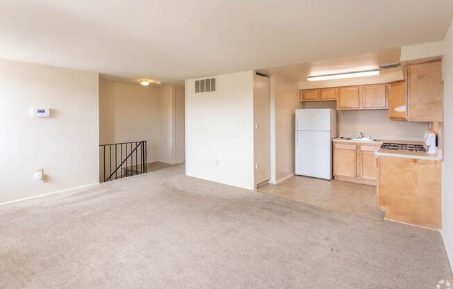 A spacious living area with a kitchenette and a refrigerator.