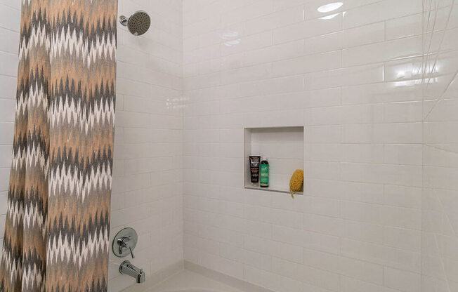A white bathtub with a shower curtain on the left.