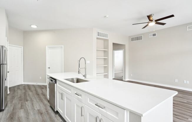 a white kitchen with a large counter top and a sink