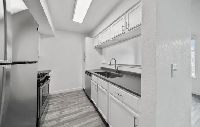 a kitchen with white cabinetry and a wooden floor