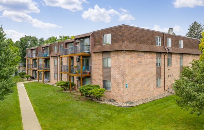 A brick building with a green lawn in front.
