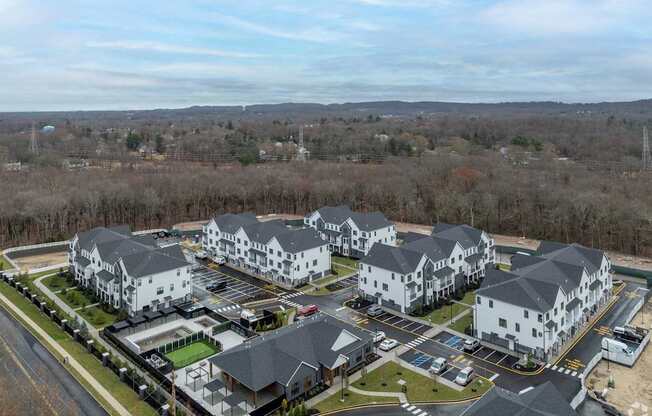 A large white building complex with a parking lot in front.