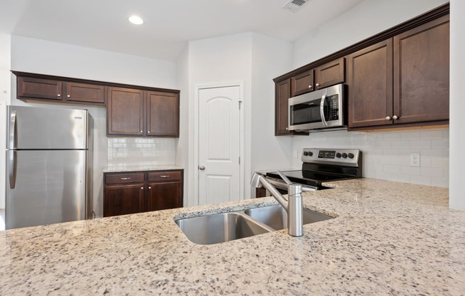 Harris Trail Luxury Townhomes for rent Richmond Hill, GA photo of a kitchen with granite counter tops and stainless steel appliances