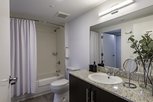 a bathroom with a sink and a toilet and a shower the gym  at a residential apartment community Resia in Decatur GA