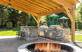 a backyard with a barbecue grill and a fire pit