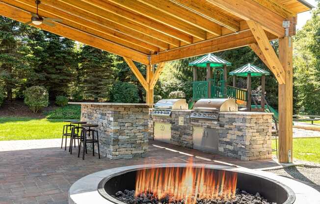 a backyard with a barbecue grill and a fire pit