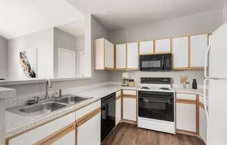 a kitchen with white cabinets and black appliances at Veranda at Centerfield, Houston, TX