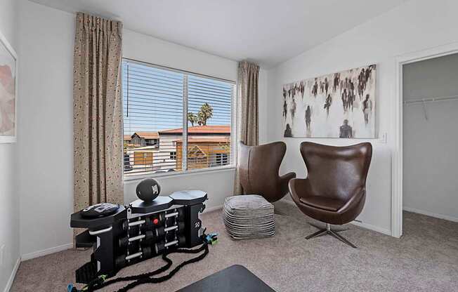 A room with a chair, a table, and a robotic vacuum cleaner.
