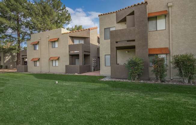 A row of houses with a green lawn in front.