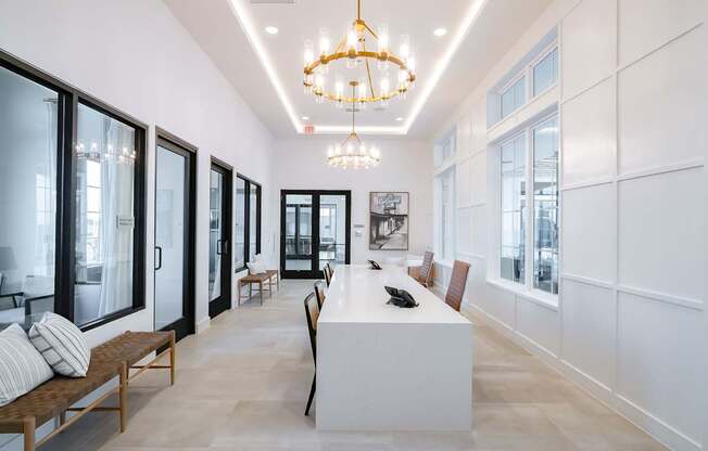 a long white reception desk with a chandelier hanging above it