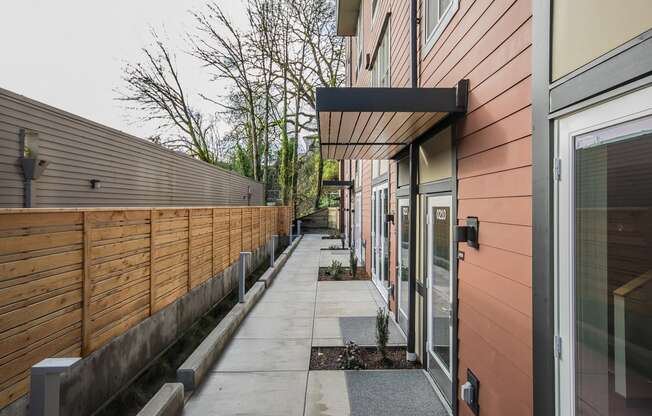 Portland, OR Apartments for Rent - Corbett Heights - Outdoor Patio Surrounded by Well-Maintained Landscaping, Large Windows, and Personal Rugs