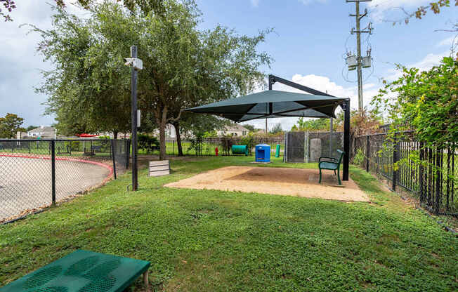 A park with a green bench and a playground.