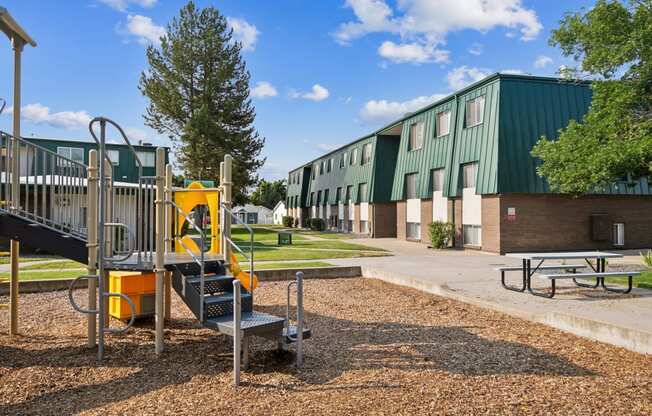 a playground with a play set in front of a building