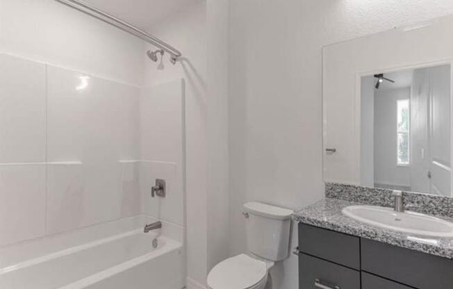 A white bathroom with a toilet, sink, and bathtub.