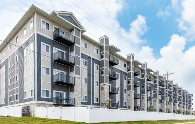 a large apartment building with balconies and a blue sky in the background