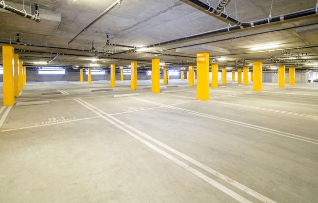 a parking garage with yellow pillars in the floor