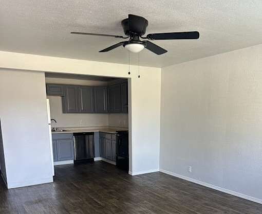 A room with a ceiling fan and wooden flooring.