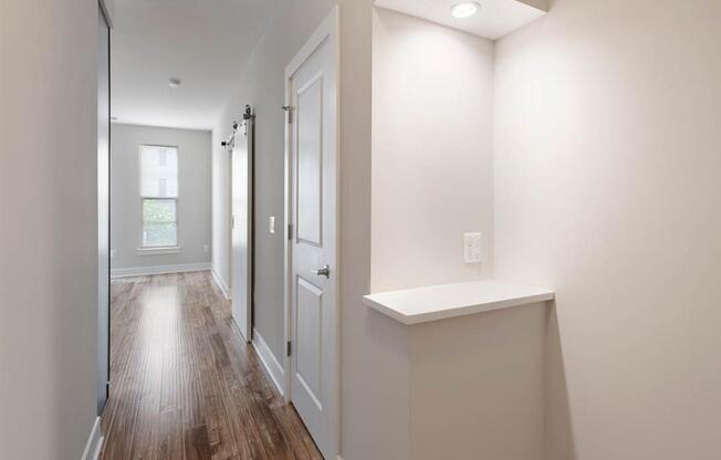 a hallway with white walls and a white door with a counter