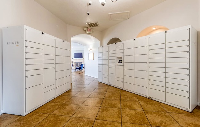 a bunch of white lockers in a room with a tile floor
