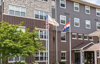 a brick building with three flags in front of it