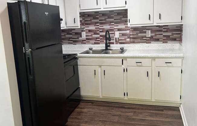 A black piano in a room with white drawers and a brown wall.