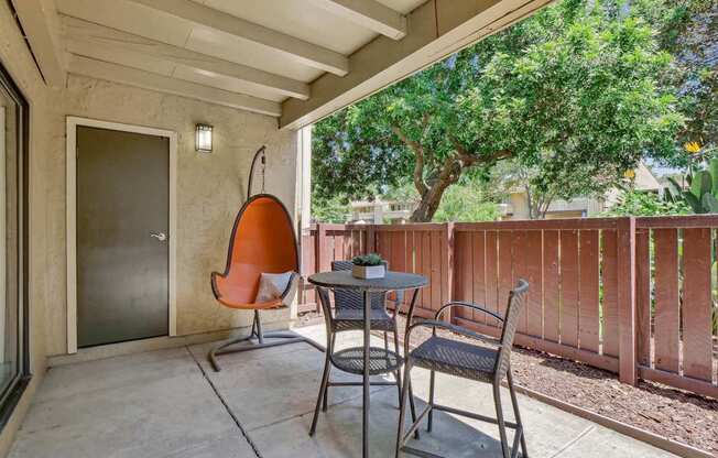 a patio with two chairs and a table and a door at Summerwood Apartments, Santa Clara