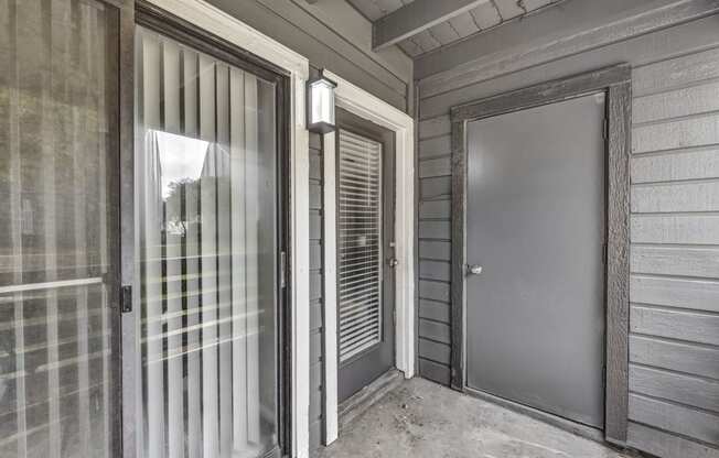 the front door of a home with a glass door and a glass screen door to