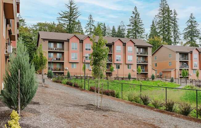 Apartment complex with a gravel driveway in front.