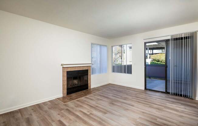 A room with a fireplace and sliding glass doors.