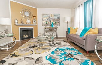 A living room with a grey couch and a fireplace at The Drake in Bossier City, LA