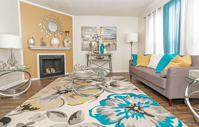 A living room with a grey couch and a fireplace at The Drake in Bossier City, LA