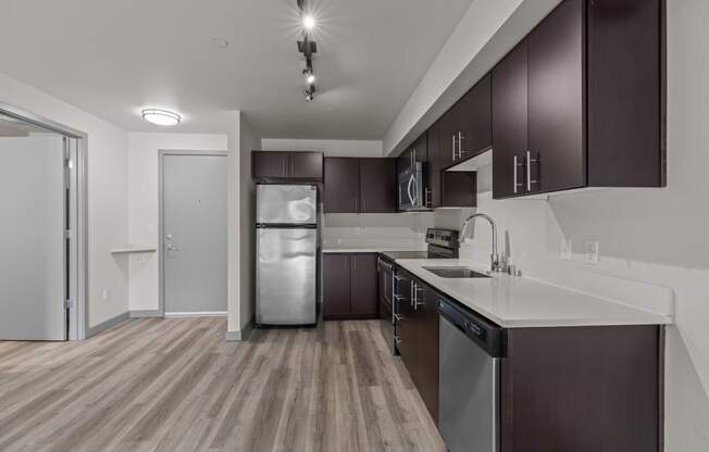 a kitchen with white countertops and a stainless steel refrigerator
