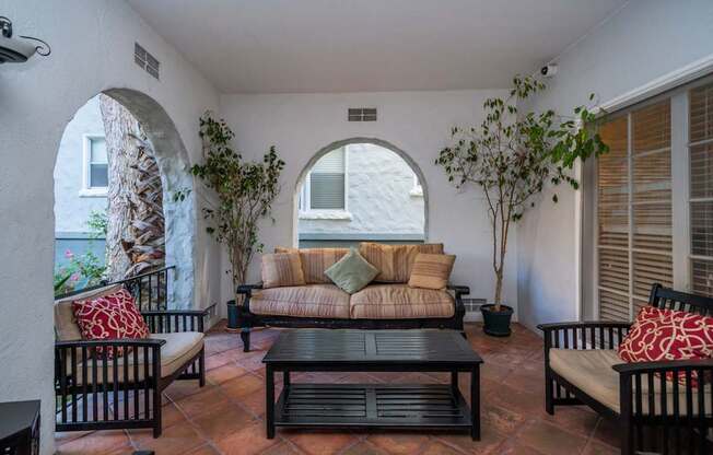 A patio with a couch, chairs, and a table.