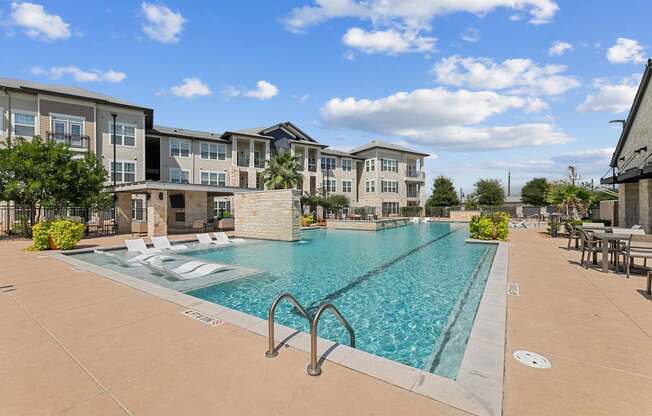 A large swimming pool in front of apartment buildings.