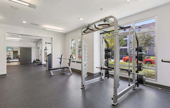 A gym with a variety of equipment including a squat rack.
