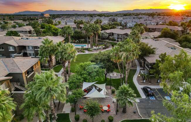 A sunset view of a residential area with palm trees and houses.