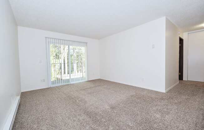 a bedroom with a large window and a carpeted floor