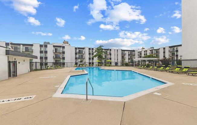 A large swimming pool in front of apartment buildings.