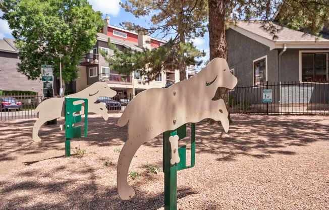 A dog sculpture is in the foreground of a park.