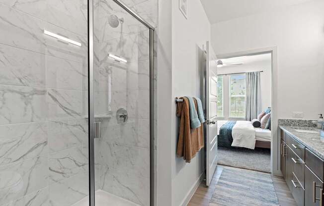 A bathroom with a walk-in shower and a marble floor.