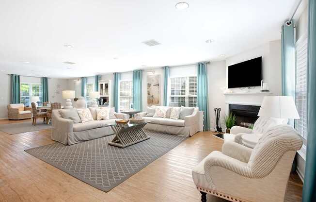 A living room with a grey rug and a white sofa.