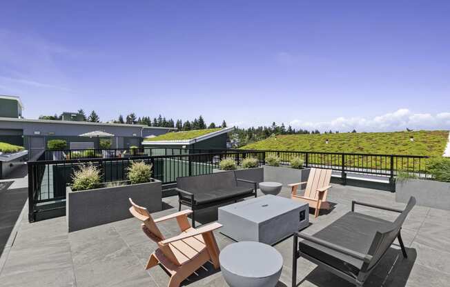 a rooftop resident patio with tables and chairs and a grassy space in the background at Sedona Apartments, Seattle, 98115
