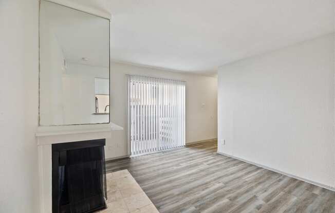 an empty living room with a fireplace and a window